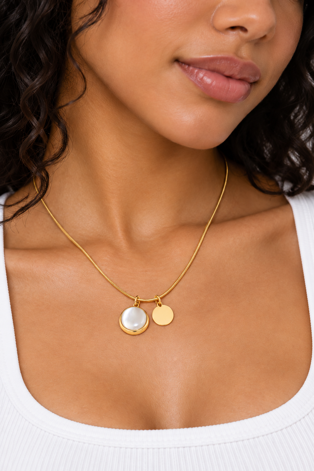 Collier doré à double pendentif nacré et médaille